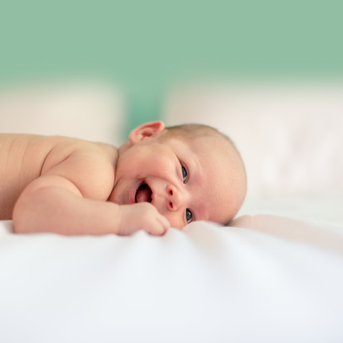 baby lying on a white soft linen