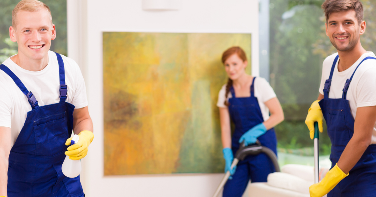 Staffs in blue overalls with yellow and blue gloves disinfecting, mopping, and vacuuming .